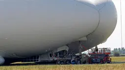 Pekerja meninjau kerusakan pesawat Airlander 10 yang gagal mendarat di Cardington Airfield, Inggris, Rabu (24/8). Pesawat yang diklaim terbesar di dunia itu rusak karena harus menukik tajam ketika melakukan pendaratan (REUTERS/Darren Staples)