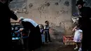Pria Yahudi ultra-Ortodoks mengayunkan ayam memutari kepala anak-anak dalam ritual Kaparot di Bnei Brak, Israel, Minggu (16/9). Ayam ini kemudian akan disembelih menjadi pengganti seseorang tersebut sebagai penebusan untuk dosa-dosanya. (AP/Oded Balilty)