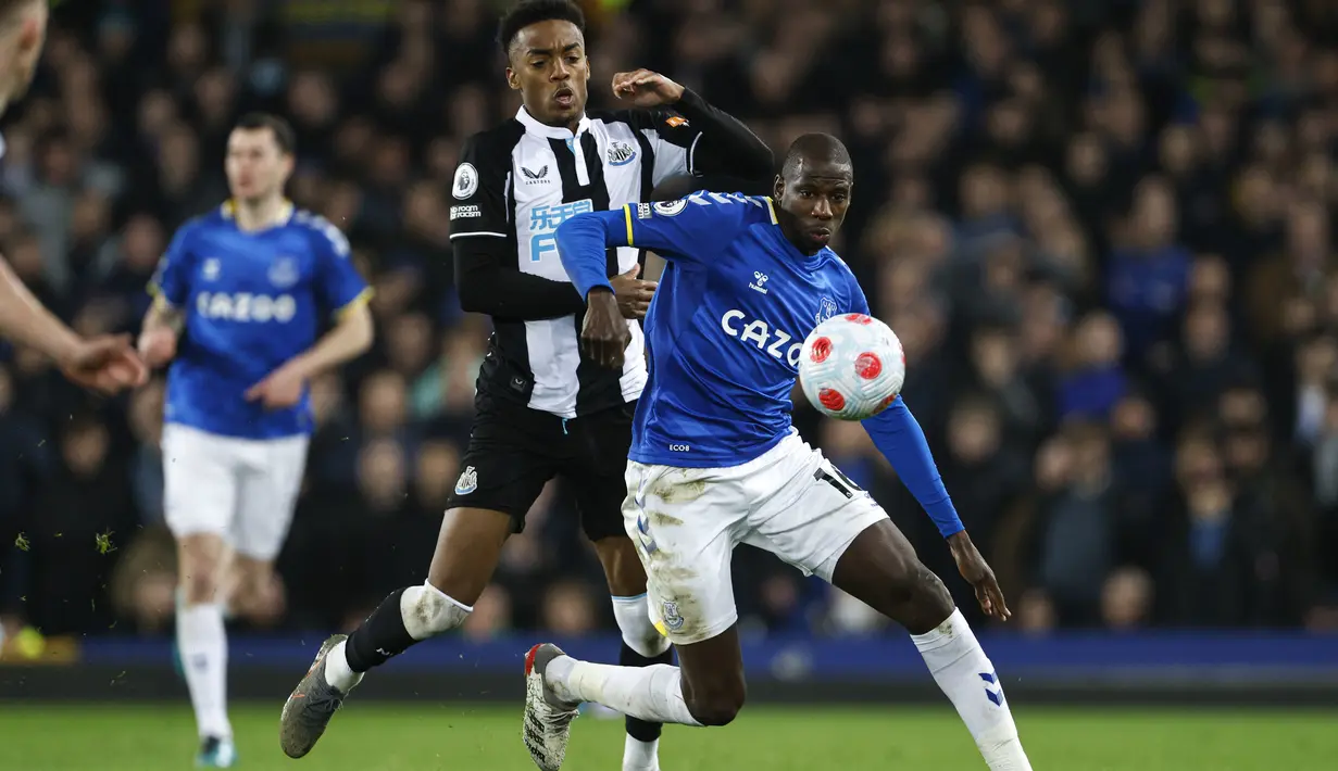 Gelandang Newcastle United Joe Willock berbeut bola dengan gelandang Everton Abdoulaye Doucoure pada lanjutan Liga Inggris di Stadion Goodison Park, Liverpool, Jumat (18/3/2022) dini hari WIB. Bertindak sebagai tuan rumah, Everton menang tipis 1-0.  (Richard Sellers/PA via AP)