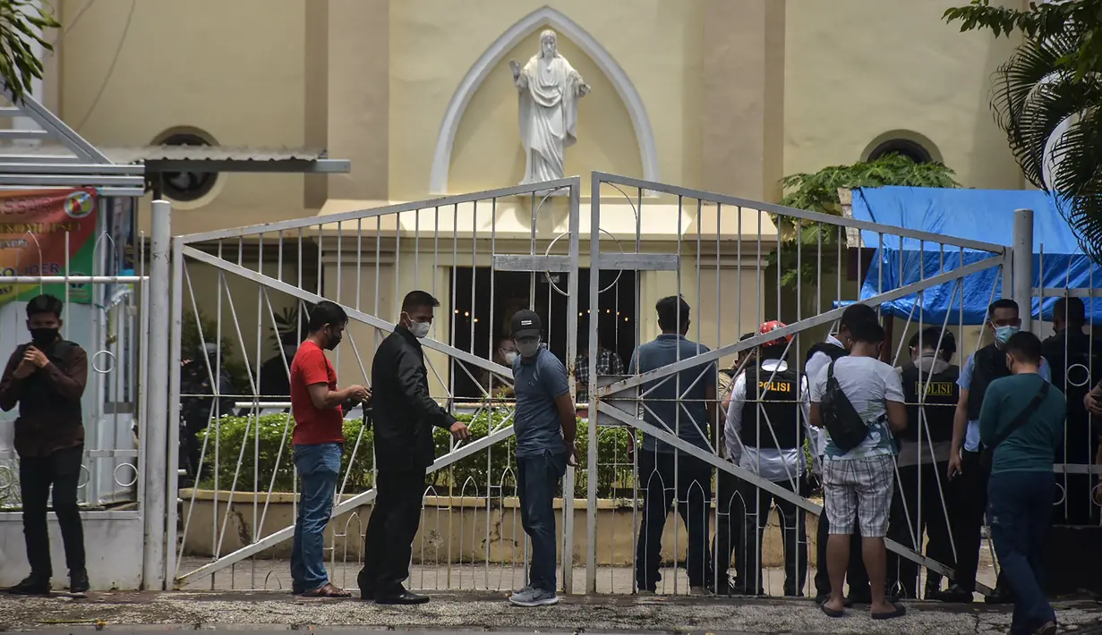 Polisi memeriksa lokasi di dekat sebuah gereja setelah ledakan di Makassarr (28/3/2021). polisi masih melakukan pengamanan di sekitar lokasi kejadian ledakan yang berada di Jalan Kartini Kota Makassar. (AFP/Indra Abriyanto)