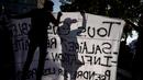Seorang pengunjuk rasa menulis pada spanduk saat demonstrasi di Lyon, Prancis, 18 Oktober 2022. Prancis berada dalam cengkeraman pemogokan transportasi dan protes untuk kenaikan upah. (AP Photo/Laurent Cipriani)
