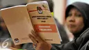 Anggota KPU membaca buku Undang-Undang tentang Penyelenggaraan Pemilihan Umum saat menghadiri acara Uji Publik Pilkada Serentak 2017 di Gedung KPU, Jakarta, Senin (18/7). (Liputan6.com/Johan Tallo)