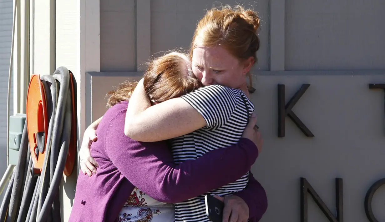 Dua orang alumni berpelukan setelah mengetahui penembakan yang terjadi di Umpqua Community College di Roseburg, Oregon, AS, Selasa (1/10/2015). 13 orang tewas dan sekitar 20 lainnya terluka akibat kejadian tersebut. (REUTERS/Steve Dipaola)