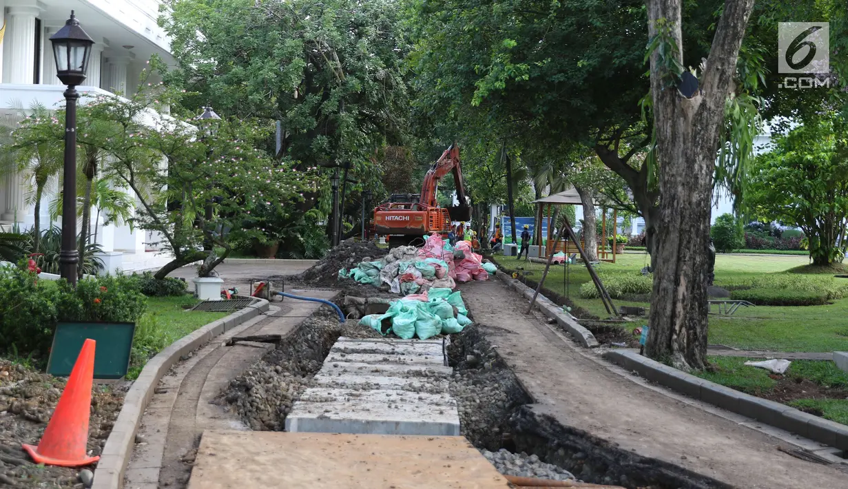 Pekerja melakukan perbaikan drainase dengan menggunakan alat berat di Kompleks Istana Kepresidenan, Jakarta, Senin (18/12). Pengerjaan rehabilitasi drainase kawasan istana kepresidenan ini guna mengantisipasi ancaman banjir. (Liputan6.com/Angga Yuniar)