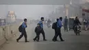 Siswa menyeberang jalan dalam perjalanan ke sekolah pada pagi yang berkabut di Lahore, Pakistan, Selasa (30/11/2021). Lahore secara konsisten menempati peringkat sebagai salah satu kota terburuk di dunia untuk polusi udara. (AP Photo/K.M. Chaudary)