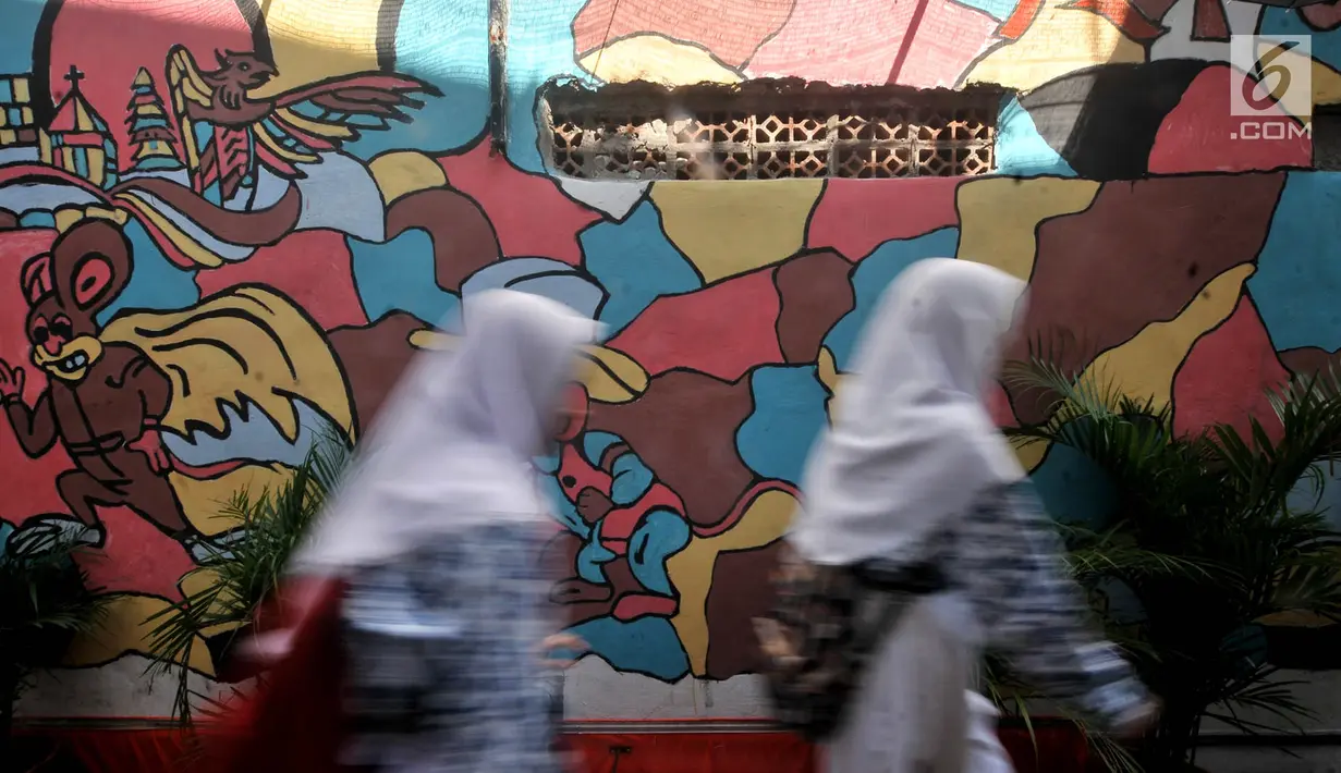 Anak sekolah melintas di depan lukisan tembok atau mural yang menghiasi gang di RT 13 RW 06, Jembatan Lima, Jakarta, Kamis (10/1). Pembuatan mural itu dimaksudkan agar lingkungan menjadi lebih tertata dan indah. (Merdeka.com/Iqbal Nugroho)
