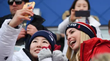 Putri Presiden AS Donald Trump yang juga penasihat senior Gedung Putih, Ivanka Trump (kanan) berswafoto dengan atlet Korea Selatan saat menonton snowboard pria pada Olimpiade Musim Dingin Pyeongchang 2018, Korea Selatan, Sabtu (24/2). (Ed JONES/AFP)