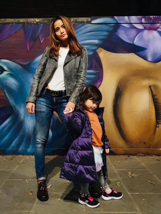 Acha Septriasa tampil manis mengenakan jaket kulit, top warna putih, dan celana jeans. Sem entara Bridgia tampil kece mengenakan t-shirt orange, skirt, dan puff jacket warna ungu. (Instagram/septriasaacha).