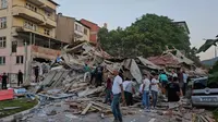 Orang-orang membersihkan puing-puing bangunan yang runtuh setelah gempa bumi di Sindirgi, Provinsi Balikesir, Turki, Minggu (10/8/2025). (Dok. Bahadir Demirceviren/IHA via AP)