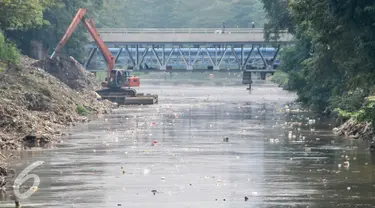  Warga menonton alat berat mengeruk kali Ciliwung di jalur Manggarai, Jakarta, Selasa (12/7). Cegah pendangkalan, Dinas Tata Air DKI Jakarta keruk kali Ciliwung. (Liputan6.com/Yoppy Renato)