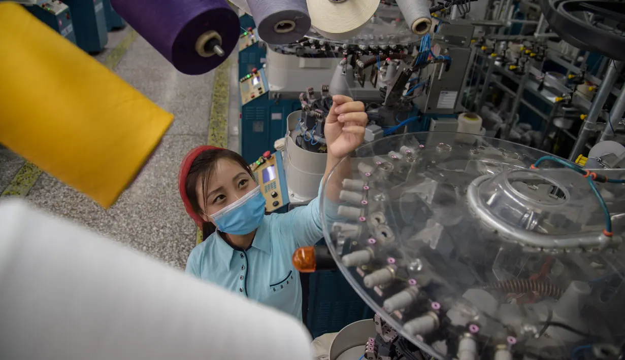 Seorang pekerja wanita mengecek benang saat berada di jalur produksi yang membuat kaus kaki pria di Pabrik Kaus Kaki Pyongyang di Korea Utara (24/5/2021). Pekerja Pabrik Kaus Kaki Pyongyang tengah telah memproduksi berbagai kaus kaki berkualitas tinggi. (AFP/Kim Won Jin)