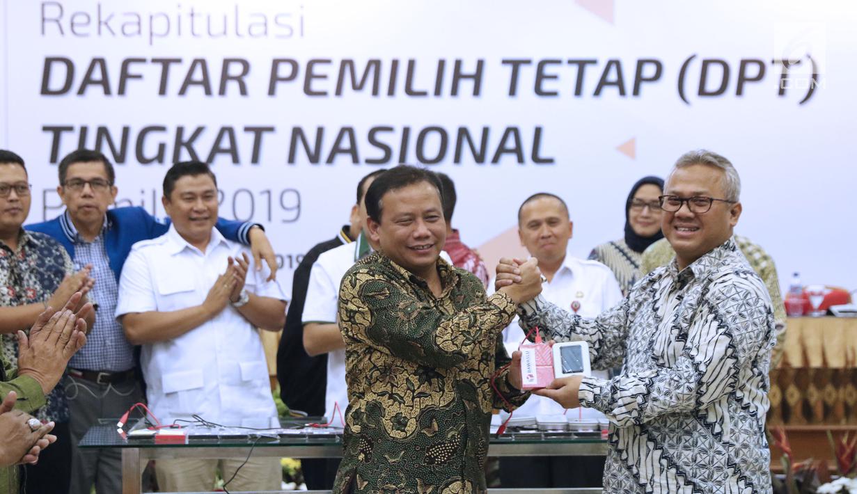 Ketua KPU RI, Arief Budiman (kanan) bersalaman dengan Ketua Bawaslu RI, Abhan saat menyerahkan soft copy DPT tingkat nasional di Jakarta, Rabu (5/9). Sebelumnya, KPU menggelar rapat pleno rekapitulasi DPT nasional. (Liputan6.com/Helmi Fithriansyah)