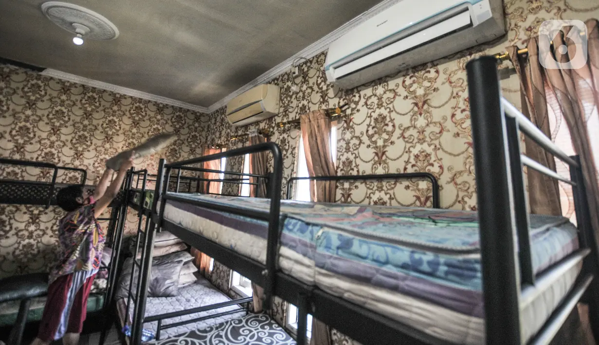 Tri (53) merapikan salah satu kamar tidur di Yayasan Mekar Jaya, Kawasan Bungur, Senen, Jakarta, Selasa (11/5/2021). Pandemi Covid-19 yang berkepanjangan melanda Indonesia menyebabkan jasa penyalur Infal yang biasa ramai di kala menjelang Lebaran kini mendadak sepi. (merdeka.com/Iqbal S Nugroho)