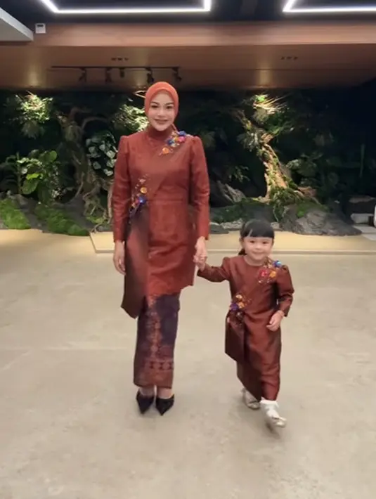 Aurel Hermansyah tampil anggun kenakan kebaya kurung berpadu dengan kain tenun. Dipadu dengan selendang bahu berpayet dan hijab polos warna merah bata [@attahalilintar]