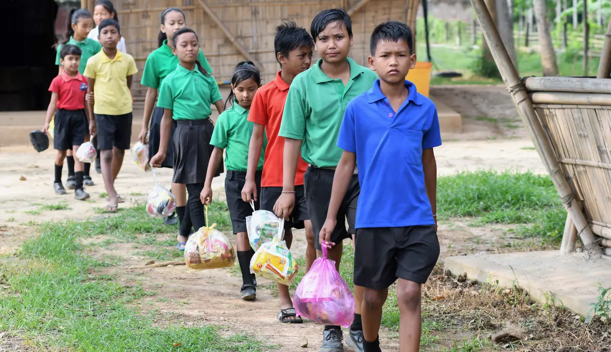 Gambar pada 20 Mei 2019, siswa India mengantre membawa tas plastik berisi sampah plastik di sekolah Forum Akshar di desa Pamohi, Guwahati. Sekolah ini mengambil pendekatan baru untuk mengatasi momok sampah plastik dengan menjadikannya sebagai syarat pengganti biaya sekolah. (Biju BORO/AFP)