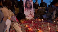 Seorang anak menaruh lilin untuk  Zainab Ansari, gadis 8 tahun yang diculik, diperkosa dan dibunuh di Islamabad, Pakistan (11/1). Sampai saat ini pelaku belum ditangkap. (AP Photo/B.K. Bangash)