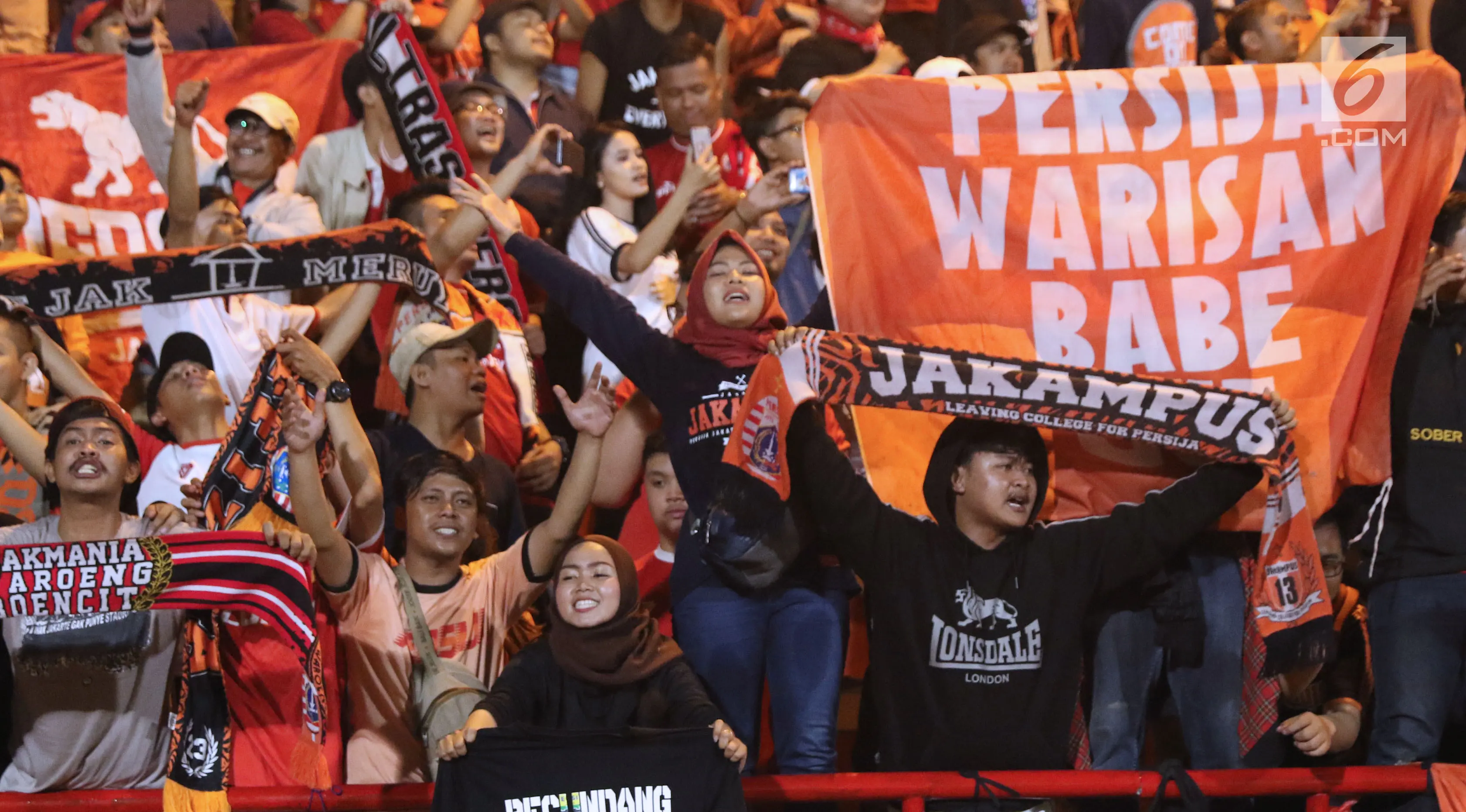 Suporter Persija bersorak merayakan kemenangan atas Persib pada lanjutan Go-Jek Liga 1 Indonesia 2018 bersama Bukalapak di Lapangan PTIK, Jakarta, Sabtu (30/6). (Liputan6.com/Helmi Fithriansyah)