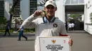 Peraih medali emas cabang olahraga angkat besi kelas -73kg putra Olimpiade Paris 2024, Rizki Juniansyah berfoto dengan medali yang diraihnya di Istana Merdeka, Jakarta, pada Kamis 15 Agustus 2024. (BAY ISMOYO/AFP)