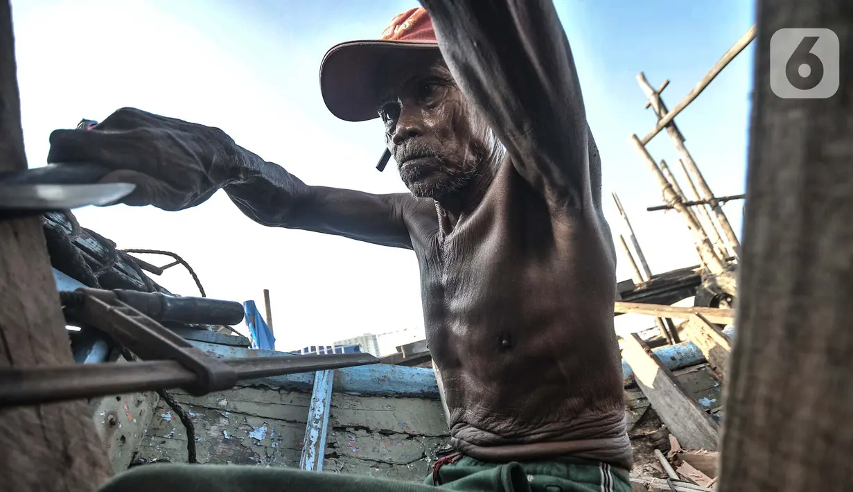 Syamsudin (71) saat menyelesaikan perbaikan kapal nelayan di kawasan Sunda Kelapa, Jakarta, Rabu (17/3/2021). Untuk perbaikan kapal, harga yang ditawarkan mulai Rp10 juta-Rp 20 juta, tergantung kerusakan dengan waktu pengerjaan 1 hingga 2 minggu. (merdeka.com/Iqbal S. Nugroho)