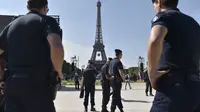 Sejumlah polisi melakukan penjagaan jelang acara Champs de Mars yang digelar untuk menyambut Piala Eropa 2016 di Paris fan zone, belakang Menara Eiffel, Prancis, Jumat (10/6/2016). (AFP/Alain Jocard)