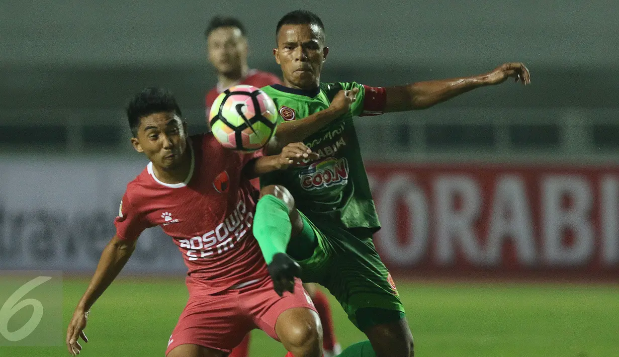 Kapten tim PS TNI, Manahati Lestusen (kanan) berebut bola dengan pemain PSM Makassar di lanjutan LIga 1 Indonesia di Stadion Pakansari, Cibinong, Kab Bogor, Senin (15/5). PS TNI unggul 2-1 atas PSM Makassar. (Liputan6.com/Helmi Fithriansyah)