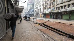 Sebuah ledakan yang diduga berasal dari gas bawah tanah merobek jalan dan menjungkirbalikkan kendaraan di jantung kota terbesar di Afrika Selatan. (Luca Sola / AFP)