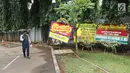 Seorang pria melintas dekat karangan bunga untuk Ketua DPR, Setya Novanto di RSCM Kencana, Jakarta, Minggu (19/11). Pada Jumat (17/11/2017), Setya Novanto dipindahkan ke RSCM untuk mendapat perawatan lebih intensif. (Liputan6.com/Herman Zakharia)