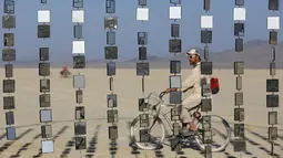 Seorang pria saat menikmati sebuah instalasi seni selama gelaran The Burning Man 2015 " Carnival of Mirrors " di sebuah gurun pasir, Nevada,(31/8/2015). Acara ini akan berlangsung selama seminggu penuh. (REUTERS/Jim Urquhart)