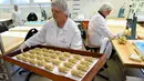Pekerja membawa adonan kue yang akan di oven di tempat pembuatan tradisional JG Niederegger GmbH di Luebeck, Jerman (5/12). Camilan unik ini merupakan makanan khas dari Luebeck, sebuah kota yang berada di utara Jerman. (AFP Photo/Stollarz)