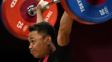 Lifter andalan Indonesia, Eko Yuli Irawan bertanding dalam kelas 61kg putra Grup A cabor angkat besi Olimpiade Tokyo 2020 di Tokyo International Forum, Minggu (25/7/2021). Eko Yuli meraih medali perak dengan total angkatan 302 kg. (AP Photo/Luca Bruno)