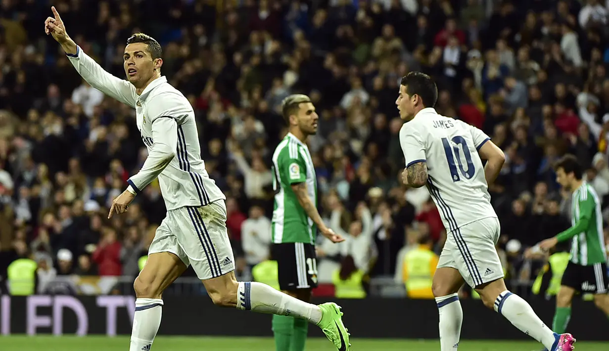Bintang Real Madrid, Cristiano Ronaldo, merayakan gol yang dicetaknya ke gawang Real Betis. Pada penghujung babak pertama Los Blancos berhasil menyamakan kedudukan menjadi 1-1 melalui gol dari CR 7. (AFP/Gerard Julien)