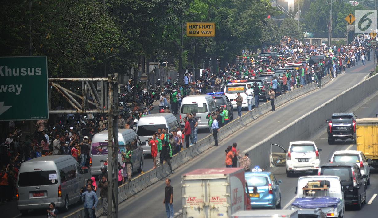 Iring-iringan mobil jenazah yang membawa almarhum Presiden ke-3 RI, BJ Habibie melintasi Jalan Gatot Subroto menuju TMP Kalibata, Jakarta, Kamis (12/9/2019). Warga secara khusus meluangkan waktu menyambut jenazah BJ Habibie untuk memberikan penghormatan terakhir. (merdeka.com/Arie Basuki)