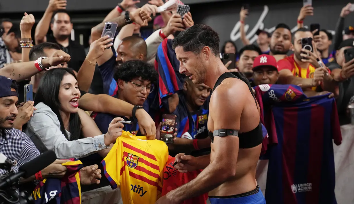 Pemain Barcelona, Robert Lewandowski, memberikan tanda tangan kepada fans setelah laga melawan AC Milan pada laga pramusim di Allegiant Stadium, Las Vegas, Rabu (2/8/2023). Barcelona menang dengan skor tipis 1-0. (AP Photo/John Locher)