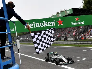 Pembalap Mercedes Nico Rosberg dari Jerman melintasi garis finish usai memenangkan Formula Satu (F1) Grand Prix Italia, di Monza, Italia Minggu (04/9). Rekan satu timnya, Lewis Hamilton, finis di urutan kedua. (REUTERS/Andrej Isakovic)