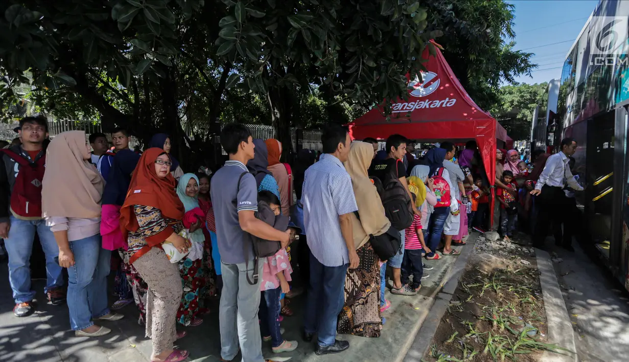 Sejumlah warga mengantre untuk menaiki bus City Tour di kawasan Masjid Istiqlal, Jakarta, Senin (25/12). Bus ini melayani sejumlah rute dan akan menaikkan serta menurunkan penumpang di kawasan wisata Jakarta. (Liputan6.com/Faizal Fanani)