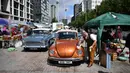 Pedagang memoles kap mesin VW Beatle di Classic Car Boot Sale, London, Inggris, 7 Agustus 2021. Classic Car Boot Sale berlangsung selama dua hari. (JUSTIN TALLIS/AFP)