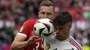 Bek Timnas Hungaria, Milos Kerkez (depan) berebut bola dengan bek Timnas Swiss, Silvan Widmer pada laga Grup A Euro 2024 di RheinEnergie Stadium, Cologne, Jerman, Sabtu (15/6/2024). (AP Photo/Darko Vojinovic)