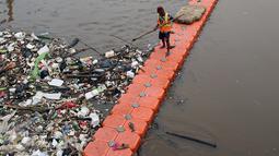 Pekerja kebersihan membersihkan sampah di Sungai Kanal Banjir Barat, Jakarta, Senin (14/11). Hujan yang terjadi di hulu Banjir Kanal Barat mengakibatkan meningkatnya debit air yang disertai sampah. (Liputan6.com/Johan Tallo)