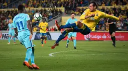 Pemain Las Palmas, Matias Aguirregaray berebut bola dengan  pemain Barcelona, Ousmane Dembele pada jornada ke-26 La Liga 2017-2018 di Estadio Gran Canaria, Kamis (1/3). Barcelona gagal menang karena tuan rumah menahan imbang 1-1. (DESIREE MARTIN/AFP)