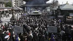 Pengunjung berdoa untuk keberuntungan selama "hatsumode," atau kunjungan pertama mereka tahun ini ke kuil atau kuil, di kuil Buddha Kawasaki Daishi di Kawasaki, dekat Tokyo, Senin (3/1/2022). (AP Photo/Eugene Hoshiko)