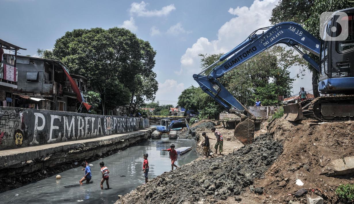 Anak-anak bermain di sekitar Kali Sentiong, Kecamatan Johar Baru, Rabu (22/9/2021). Pengerukan lumpur Kali Sentiong sekaligus mencegah banjir di kawasan tersebut yang kerap terjadi saat musim hujan. (merdeka.com/Iqbal S. Nugroho)