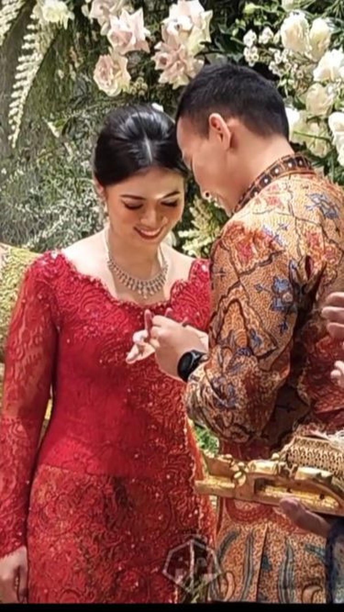 Potret Iptu Hafiz memasangkan cincin ke jari manis Angela. Cucu Jenderal Hendropriyono itu terlihat senyum bahagia.