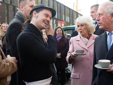 Pangeran Charles bersama istrinya, Duchess of Cornwall Camilla menikmati teh sambil berbincang ketika mengunjungi Swiss Cottage Farmers Market di London utara, Rabu (6/11/2019). Kunjungan Charles dan Camila untuk mengucapkan selamat dan memperingati ulang tahun ke-20 pasar tersebut. (Eddie Mulhollan