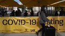 Pelancong mengantre untuk dites COVID-19 di Bandara Internasional Los Angeles di Los Angeles, Senin (20/12/2021). Departemen Kesehatan Masyarakat Los Angeles County melaporkan jumlah kasus baru harian COVID-19 meningkat tiga kali lipat selama seminggu. (AP Photo/Jae C.Hong)