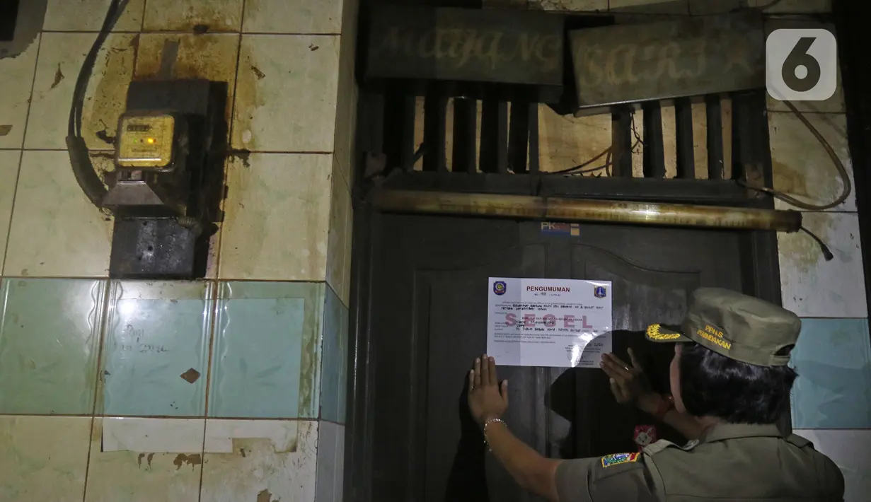 Petugas menyegel salah satu warung remang-remang di gang royal kawasan Penjaringan, Jakarta, Senin (10/2/2020). Pemkot Jakarta Utara bersama instansi terkait, melakukan penyegelan bangunan dan Penertiban Pemakaian Tenaga Listrik (P2TL) di kawasan Gang Royal. (Liputan6.com/Herman Zakharia)