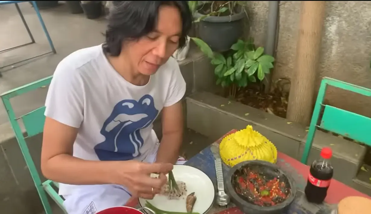 Bimbim mengulung-gulung petai cina yang masih muda kemudian dicocolkan sambal yang masih di cobek dan dimakan. [Youtube/ALZ Family Bimbim Slank]