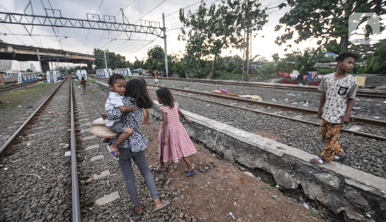 Anak-anak saat bermain di dekat rel kereta api di kawasan Bahari Ujung, Tanjung Priok, Jakarta Utara, Selasa (24/5/2022). Minimnya fasilitas dan ruang terbuka hijau di kawasan tersebut menyebabkan anak-anak setempat memilih bermain di sekitar perlintasan kereta api yang dapat membahayakan keselamatan mereka. (merdeka.com/Iqbal S Nugroho)