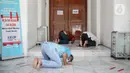 Sejumlah warga melaksanakan salat zuhur di halaman depan Masjid Cut Meutia, Jakarta, Jumat (18/9/2020). Pemprov DKI Jakarta kembali meniadakan kegiatan ibadah salat Jumat dan salat lima waktu berjemaah di semua Masjid Raya selama PSBB. (Liputan6.com/Faizal Fanani)