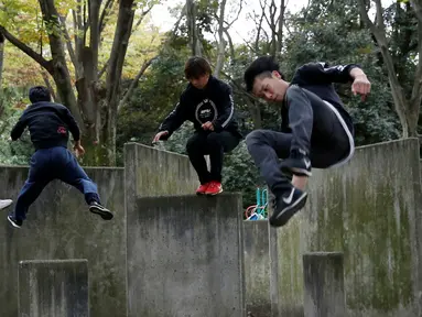 Juni Sato bersama rekan-rekannya beraksi unjuk kemampuan melakukan parkour di sebuah taman di Tokyo, Jepang (2/11). Karena cintanya dengan seni olahraga ekstrem ini, Sato mendirikan sekolah parkour yang diberi nama SENDAI X-TRAIN. (Reuters/Kim Kyung-Hoon)