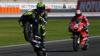 Pembalap Monster Energy Yamaha Valentino Rossi menampilkan wheelie pada latihan bebas ketiga (FP3) MotoGP Valencia di Sirkuit Ricardo Tormo, Sabtu (16/11/2019). Rossi menempati posisi keempat pada FP3 MotoGP Valencia. (PIERRE-PHILIPPE MARCOU/AFP)